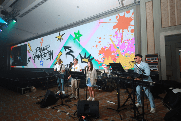 MGEN’s employee music group Power Generation, including MGEN President and CEO Emmanuel V. Rubio, performs during company events and employee activities.